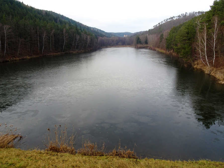 Stausee Kronsegg im Winter mit Burgruine Kronsegg im Hintergrund